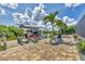 Private dock and boat lift with waterside seating and lush tropical landscaping at 9532 Miami Cir, Port Charlotte, FL 33981