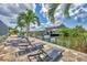 Waterfront view of the private dock with boat lift, covered seating area and lounge chairs at 9532 Miami Cir, Port Charlotte, FL 33981