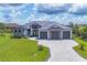 Beautiful single-Gathering home showcasing a 3-car garage, well-manicured lawn, and decorative stone facade at 9532 Miami Cir, Port Charlotte, FL 33981