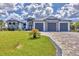 Beautiful single-Gathering home showcasing a 3-car garage, well-manicured lawn, and decorative stone facade at 9532 Miami Cir, Port Charlotte, FL 33981