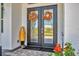 Charming double front doors decorated with autumn wreaths and complimented by beautiful flower arrangements at 9532 Miami Cir, Port Charlotte, FL 33981