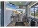 Outdoor kitchen featuring stone accents, stainless steel appliances, and a charming view at 9532 Miami Cir, Port Charlotte, FL 33981
