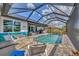 Beautiful screened-in pool area with outdoor seating, kitchen and view of the waterway at 9532 Miami Cir, Port Charlotte, FL 33981