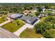 Overhead angle of a single-Gathering home featuring mature landscaping, an expansive lawn, and an adjacent screened in porch at 9869 Gulfstream Blvd, Englewood, FL 34224