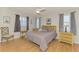 Cozy bedroom with hardwood floors, a ceiling fan, and a comfortable bed with ample natural light at 9869 Gulfstream Blvd, Englewood, FL 34224