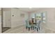 Bright dining room with wainscoting, laminate flooring, and view of the outdoors at 9869 Gulfstream Blvd, Englewood, FL 34224