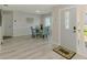 Cozy dining area off foyer, featuring plank flooring, a round dining table, and natural light at 9869 Gulfstream Blvd, Englewood, FL 34224