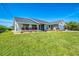 Inviting one-story home with lush lawn, colorful landscaping, and a screened front porch at 9869 Gulfstream Blvd, Englewood, FL 34224