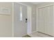 Inviting foyer featuring a gray front door, a coat closet and plank flooring at 9869 Gulfstream Blvd, Englewood, FL 34224