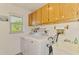 Laundry room equipped with modern appliances, ample storage cabinets and a convenient utility sink at 9869 Gulfstream Blvd, Englewood, FL 34224