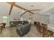 Living room with wooden beams, comfortable seating, and view into the kitchen at 9869 Gulfstream Blvd, Englewood, FL 34224