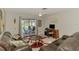 Bright living room with sliding glass door, desk, and comfortable seating at 9869 Gulfstream Blvd, Englewood, FL 34224