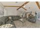 Inviting living room with wood beams, gray flooring, an open floor plan, and comfortable leather seating at 9869 Gulfstream Blvd, Englewood, FL 34224