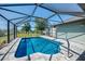 Inviting screened-in pool area with clear blue water and gray brick pavers provides a relaxing outdoor space at 9869 Gulfstream Blvd, Englewood, FL 34224