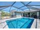 Inviting screened-in pool with clear blue water, patio, and outdoor bar, perfect for entertaining guests at 9869 Gulfstream Blvd, Englewood, FL 34224
