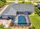 A screened-in pool area surrounded by well-maintained landscaping, viewed from above at 9869 Gulfstream Blvd, Englewood, FL 34224