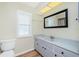 Bright bathroom with a large vanity, framed mirror, and window with shutters at 10116 Melanie Ave, Englewood, FL 34224