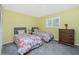 Sunny bedroom with two twin beds, dresser, and a bright shuttered window at 10116 Melanie Ave, Englewood, FL 34224