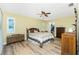 Comfortable bedroom with ceiling fan, wood-look flooring, and shuttered windows at 10116 Melanie Ave, Englewood, FL 34224