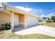 Exterior showing a white garage door and front door with a driveway and green lawn at 10116 Melanie Ave, Englewood, FL 34224