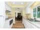 Bright eat-in kitchen with white cabinets, stainless sink, and view into the dining area at 10116 Melanie Ave, Englewood, FL 34224