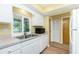 This kitchen features white cabinets and a stainless steel sink with a view of the lanai at 10116 Melanie Ave, Englewood, FL 34224