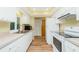 Functional kitchen featuring white cabinetry, wood-look floors, and lots of natural light at 10116 Melanie Ave, Englewood, FL 34224