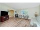 Bright living room featuring neutral paint, lots of natural light, and wood-look flooring at 10116 Melanie Ave, Englewood, FL 34224