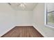 This is an empty bedroom featuring wood-style flooring and a modern ceiling fan with great natural light at 10242 Hallendale Dr, Port Charlotte, FL 33981