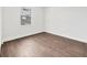 This empty bedroom offers wood-style floors and natural light from the window at 10242 Hallendale Dr, Port Charlotte, FL 33981
