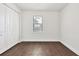 This is an empty bedroom featuring wood-style flooring, a window, and a closet at 10242 Hallendale Dr, Port Charlotte, FL 33981