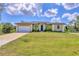 Well maintained, single-story home with a two car garage and a freshly manicured lawn at 10242 Hallendale Dr, Port Charlotte, FL 33981