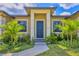 A walkway leads to the home's front entrance framed by columns and complemented by fresh landscaping at 10242 Hallendale Dr, Port Charlotte, FL 33981