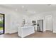 Well lit kitchen features white cabinets, stainless steel appliances and a central island at 10242 Hallendale Dr, Port Charlotte, FL 33981