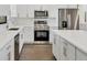 Close up shot of a modern kitchen featuring stainless steel appliances, white cabinets and quartz countertops at 10242 Hallendale Dr, Port Charlotte, FL 33981