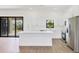 This modern kitchen is outfitted with white cabinets, stainless steel appliances, and an island counter at 10242 Hallendale Dr, Port Charlotte, FL 33981