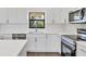 Bright kitchen features white cabinets, stainless steel appliances, and a garden window at 10242 Hallendale Dr, Port Charlotte, FL 33981