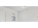 A bright room has a door on the left and a single window with blinds at 10242 Hallendale Dr, Port Charlotte, FL 33981