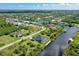 Aerial view of a waterfront home with a pool in a scenic neighborhood with lush landscaping at 10454 Atenia St, Port Charlotte, FL 33981