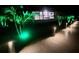 Pathway with lights and palm trees leading to an illuminated outdoor living area, perfect for evening relaxation at 10454 Atenia St, Port Charlotte, FL 33981