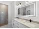 Elegant bathroom featuring double sinks, white marble countertops, and a large, lighted mirror at 10454 Atenia St, Port Charlotte, FL 33981