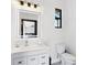 A well-lit powder room featuring a modern vanity, mirror, and fixtures, offering a clean and stylish design at 10454 Atenia St, Port Charlotte, FL 33981