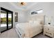 Bright bedroom with a white, full bed, wood floors, and access to the pool area at 10454 Atenia St, Port Charlotte, FL 33981