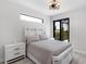 Bright bedroom featuring a white bed frame, modern light fixture, and view of the screened lanai at 10454 Atenia St, Port Charlotte, FL 33981