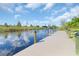 Newly constructed dock with inviting waterfront views, surrounded by lush vegetation on a sunny day at 10454 Atenia St, Port Charlotte, FL 33981