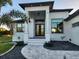Front entrance of home with columns and a landscaped walkway with decorative rock at 10454 Atenia St, Port Charlotte, FL 33981