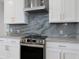 Modern kitchen features white cabinets with gold hardware and a marble backsplash at 10454 Atenia St, Port Charlotte, FL 33981