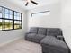 A comfortable living area features natural light, a large window, and a grey sofa at 10454 Atenia St, Port Charlotte, FL 33981
