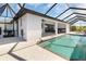 Covered lanai with an outdoor kitchen overlooks a swimming pool and seating area at 10454 Atenia St, Port Charlotte, FL 33981