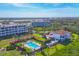 Beautiful aerial view of condominiums with a shared pool and tropical landscaping on a sunny day at 11100 Hacienda Del Mar Blvd # G-304, Placida, FL 33946